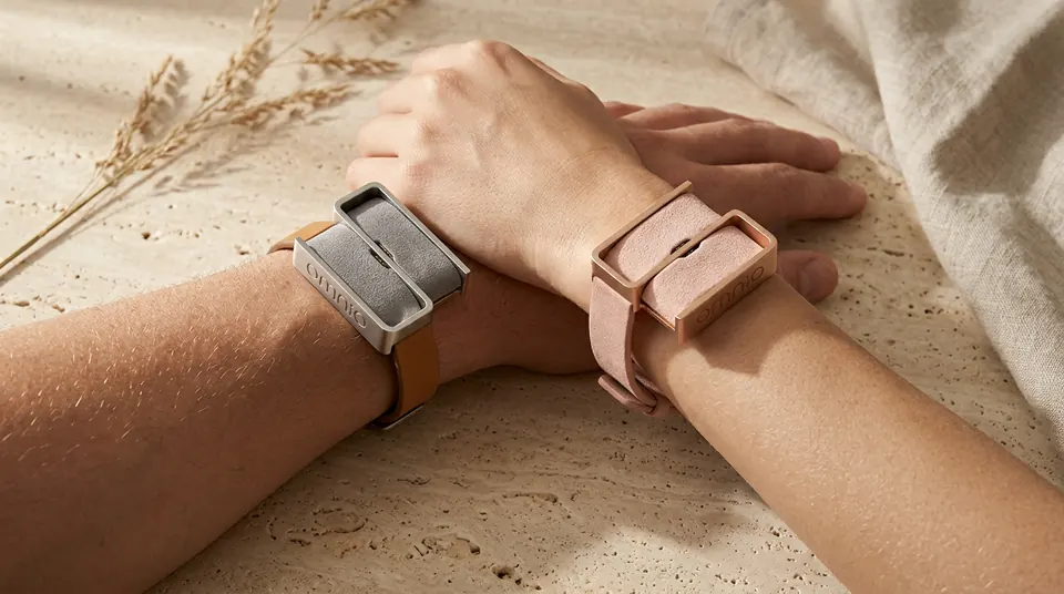 Filo: two wrists, gray and rose bands, on stone